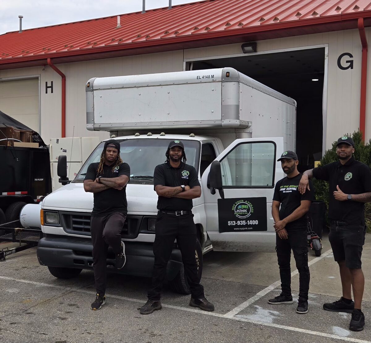 The NYA Junk Removal crew standing beside their 15-foot white box truck.
